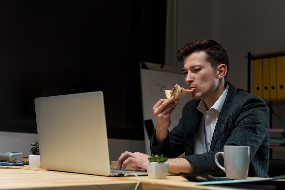 Un employé de nuit qui mange une pizza